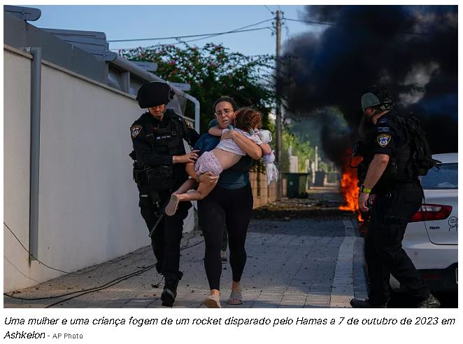 Uma mulher e uma criança fogem de um rocket disparado pelo Hamas a 7 de outubro de 2023 em Ashkelon